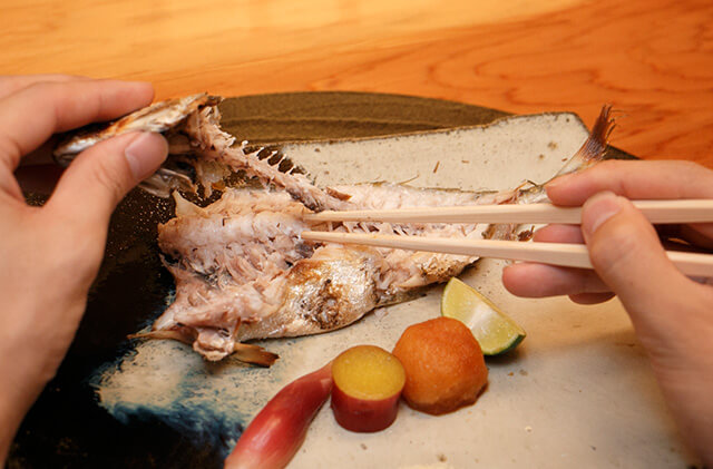 上身を食べ終えたら左手で魚の頭を押さえ、骨と身の間に箸を入れて骨を外します